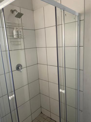 La salle de bains est pourvue d'une douche et de carrelage blanc. dans l'établissement Blissful Stay, à Potchefstroom