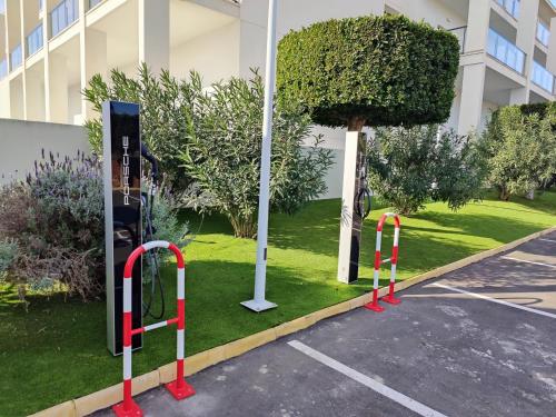 a parking lot with red and white barriers next to a building at Cabogata Beach Hotel in Retamar