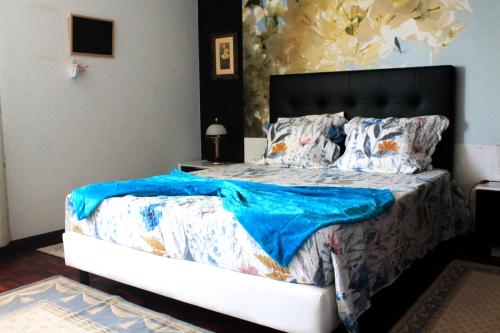 um quarto com uma cama com um cobertor azul em GuestHouse Pombinha em Nazaré