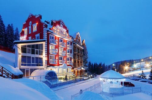 un hôtel dans la neige la nuit dans l'établissement Chevalier Hotel & SPA, à Bukovel