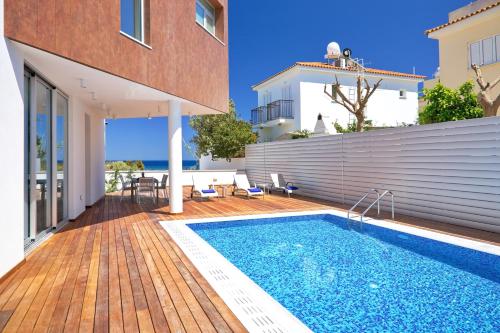a villa with a swimming pool and a house at Sunrise Seaview Villas - Camelia in Paralimni