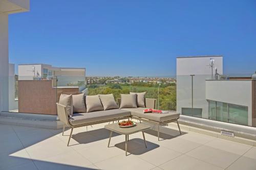 a living room with a couch and a table at Sunrise Seaview Villas - Camelia in Paralimni