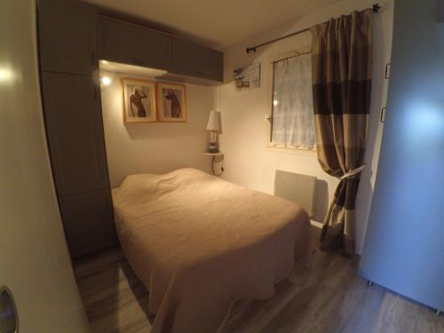een kleine slaapkamer met een bed en een raam bij ABBAYE DU CAP Très joli T2 moderne proche port ABBAYE DU CAP Cap d'Agde in Cap d'Agde
