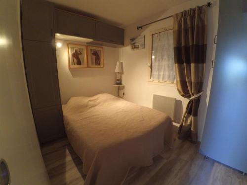 une petite chambre avec un lit et une fenêtre dans l'établissement ABBAYE DU CAP Très joli T2 moderne proche port ABBAYE DU CAP Cap d'Agde, au Cap d'Agde