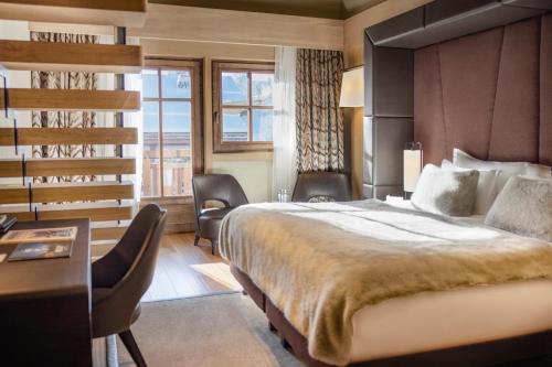 a hotel room with a large bed and a desk at Armancette - The Leading Hotels of the World in Saint-Gervais-les-Bains