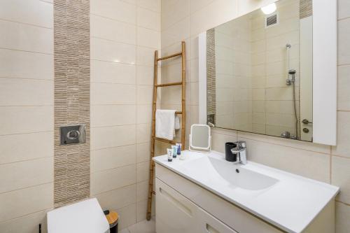 ein Bad mit einem Waschbecken und einem Spiegel in der Unterkunft Spacious 3 BDR in Florentine in Tel Aviv