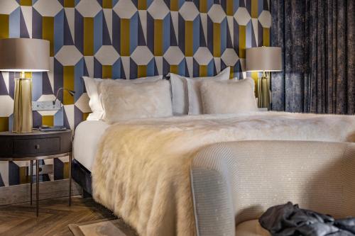 a bedroom with a bed and a striped wall at Armancette - The Leading Hotels of the World in Saint-Gervais-les-Bains