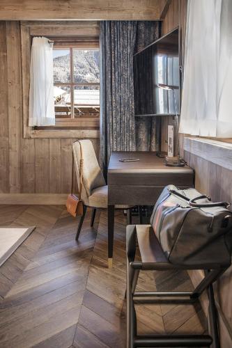 a desk and chairs in a room with a window at Armancette - The Leading Hotels of the World in Saint-Gervais-les-Bains