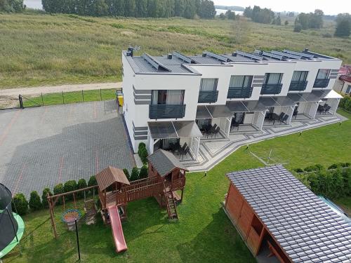 eine Luftansicht eines Gebäudes mit Spielplatz in der Unterkunft Over Lake-domki,apartamenty in Mielno