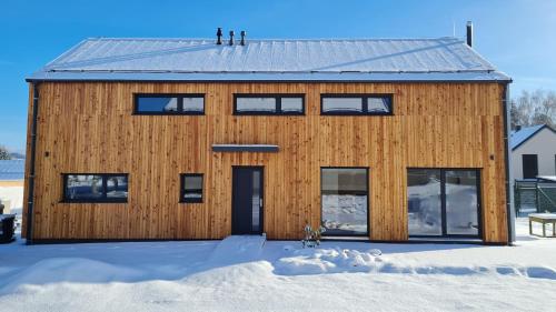 a wooden house in the snow at Apartmány Zámecká in Jilemnice