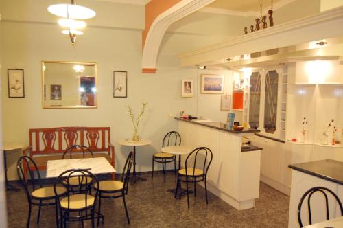 a restaurant with a table and chairs and a counter at Pefkakia Park in Ermoupoli