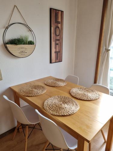 tavolo da pranzo con sedie bianche intorno di Pine Tree Apartment a Porto