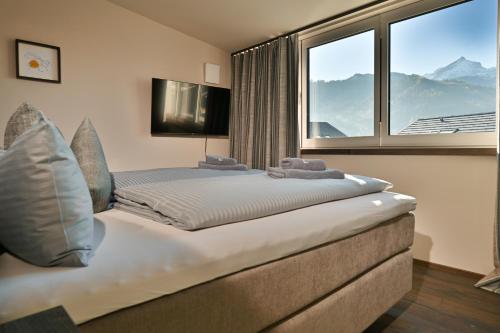 a bedroom with a large bed with a large window at BergChalet in Garmisch-Partenkirchen
