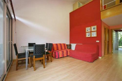 ein Wohnzimmer mit einem roten Sofa und einem Tisch in der Unterkunft Apartamentos Turísticos Silvano Posada de Llanes in Posada de Llanes