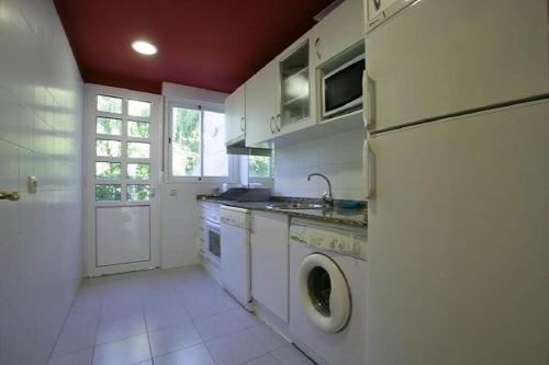 eine Küche mit einer Waschmaschine und einem Geschirrspüler in der Unterkunft Apartamentos Turísticos Silvano Posada de Llanes in Posada de Llanes