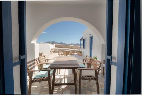 an archway with a table and chairs on a balcony at Christina's House in Koufonisia