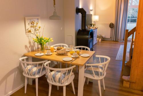 einem Esstisch mit Stühlen und einem Tisch mit Blumen darauf in der Unterkunft Ora in Westermarkelsdorf