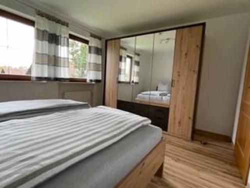 1 dormitorio con 1 cama grande y espejo en Haus Gertraud Schreiner, en Neuschönau
