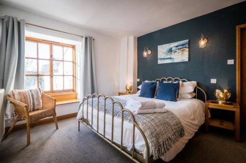 Un dormitorio con una cama con paredes azules y una ventana en Stunning cottage Grade 2 listed with parking and Hot Tub en Bowness-on-Windermere