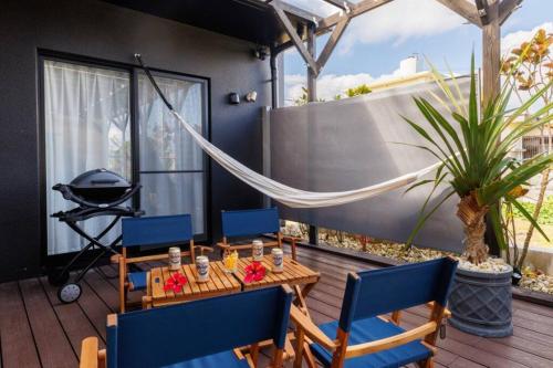 a patio with a table and chairs and a grill at テラスでBBQ&サウナ&ジャグジー付き 築浅おしゃれな貸別荘 最大16名宿泊可能 Cottage Uruma in Uruma