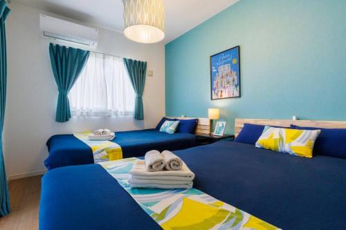 うるま市にあるテラスでBBQ&サウナ&ジャグジー付き 築浅おしゃれな貸別荘 最大16名宿泊可能 Cottage Urumaの青い壁のドミトリールーム ベッド2台