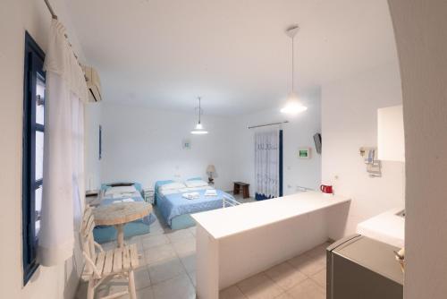 a white room with a bed and a table at Christina's House in Koufonisia