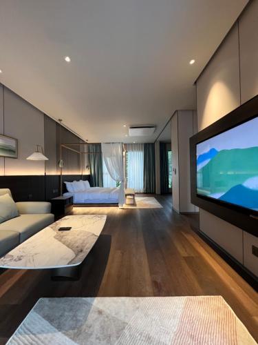 a living room with a large flat screen tv at Looma Private Pool Villas in Pantai Cenang