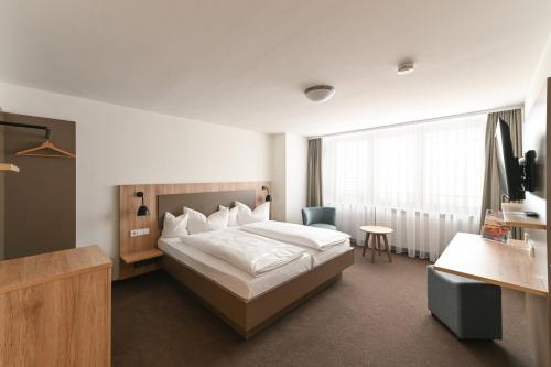 Habitación de hotel con cama y TV en Landschloss Korntal en Korntal-Münchingen