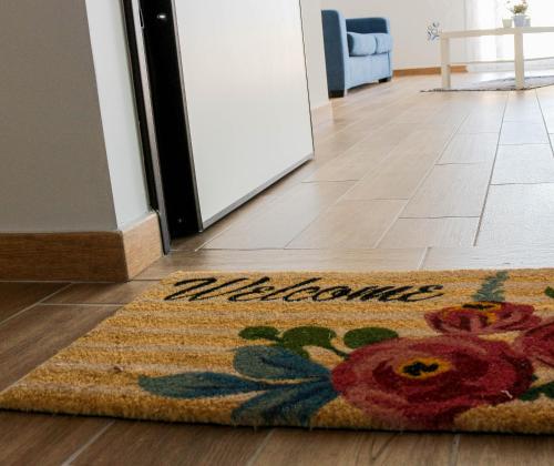 - un tapis sur le sol en face d'une porte dans l'établissement Maison Matilda, à Capo dʼOrlando