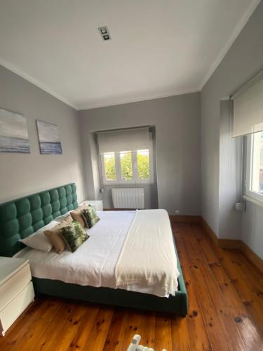 a bedroom with a large bed with a green headboard at Belem Aloja in Lisbon