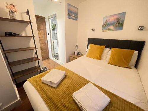 1 dormitorio con 1 cama grande con almohadas amarillas en ND Hotel - Hyde Park, en Londres