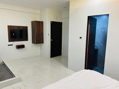 een slaapkamer met twee zwarte deuren en een tv aan de muur bij Hotel New City Light in Surat