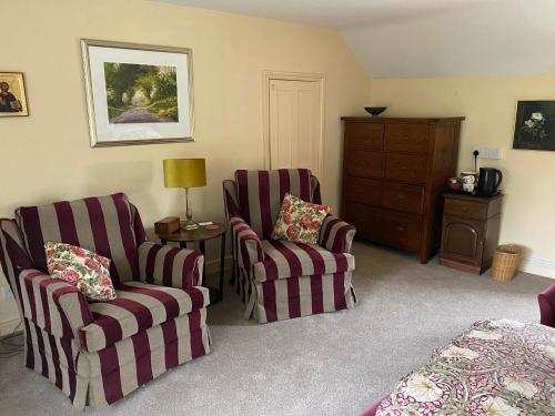 uma sala de estar com duas cadeiras e uma cómoda em Jeffrey’s B and B 