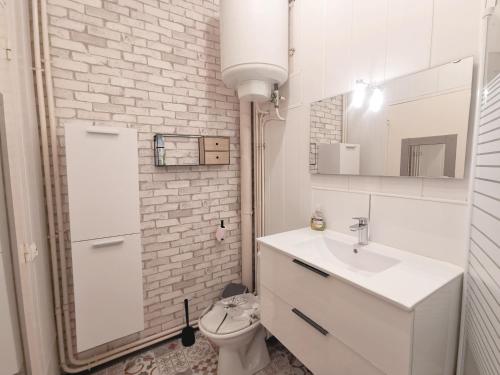 une salle de bain blanche avec un lavabo et des toilettes dans l'établissement Le paradis normand, à Saint-Pierre-en-Port