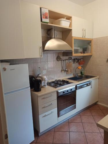 uma cozinha com um fogão e um frigorífico branco em Stanza Maggiore em Parma