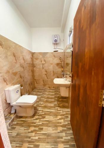 a bathroom with a toilet and a sink at Nirosha Guest House in Galle