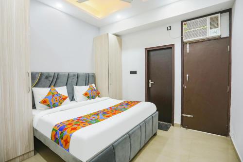 een slaapkamer met een groot wit bed met kleurrijke kussens bij FabHotel Rasa Arcade in Ghaziabad