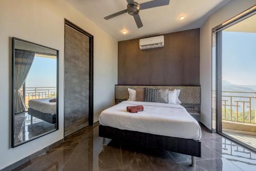 a bedroom with a large bed and a balcony at SaffronStays HeavOne Trio, Lonavala in Lonavala
