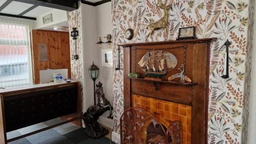 een woonkamer met een open haard en een muur bij Colbourn Bed and Breakfast in Colwyn Bay