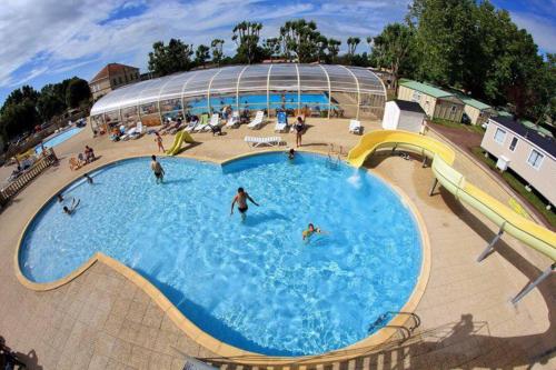a large swimming pool with people playing in it at Mobilhome 4/6 personnes proche La Palmyre, Royan in Saint-Augustin