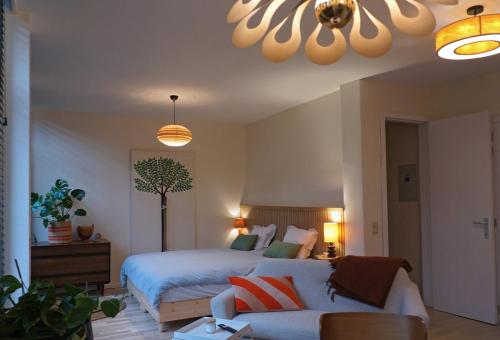 een slaapkamer met een bed en een bank bij l'ostendaise in Oostende