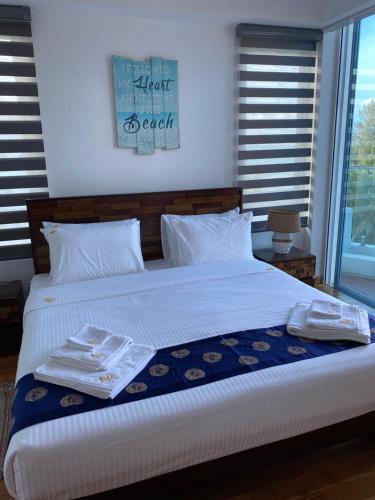 a bed with white sheets and towels on it at Luxury Penthouse, Nilaveli in Trincomalee