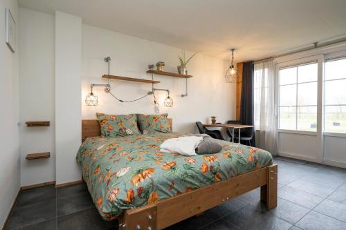 a bedroom with a bed and a table and a window at Johanneshoeve - de mooiste plek op Texel in Den Hoorn