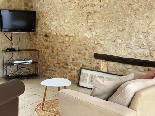 Champagne-et-Fontaine的住宿－Métairie des Gâcheries，客厅配有沙发和墙上的电视