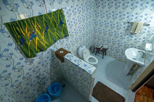 a bathroom with a toilet and a sink at Bamboo Banks Farm & Guest House in Masinagudi