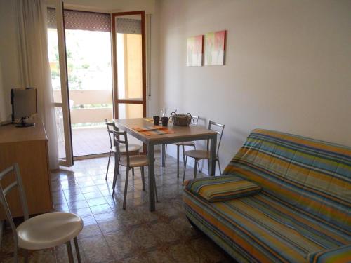 un soggiorno con tavolo, sedie e divano di Bright flat with a wide terrace - Beahost Rentals a Bibione