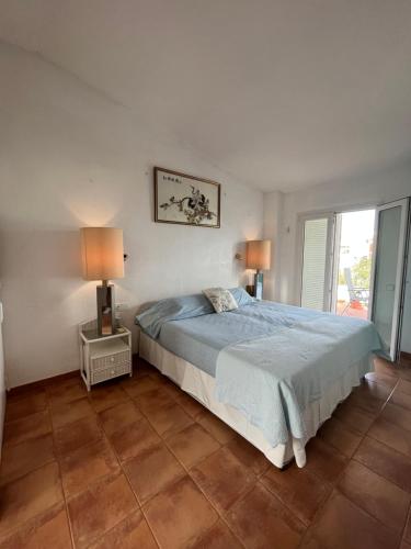 a bedroom with a bed and two lamps in it at Attic in Cadaques in Cadaqués