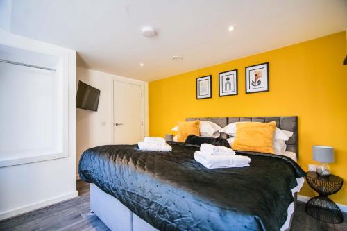 - une chambre avec un grand lit aux murs jaunes dans l'établissement Apartment 1 - The Crescent, à York