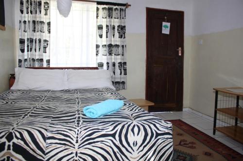 Un dormitorio con una cama con un objeto azul. en REED MAT LODGE, en Lusaka