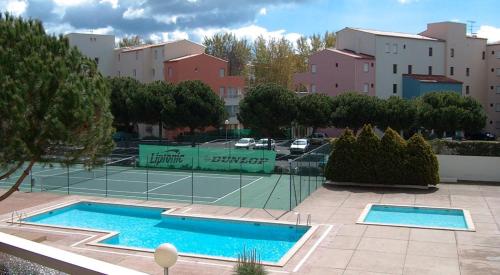 um campo de ténis ao lado de um campo de ténis em NAUTICAP Joli T2 alcôve piscine tennis NAUTICAP Plage Richelieu cap d'Agde em Cap d'Agde